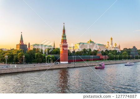 View of Kremlin with Vodovzvodnaya tower, Grand Kremlin Palace from repaired Bolshoy Kamenny Bridge in Moscow city on sunny summer day. Cruise ship sails on the Moscow river 127774887