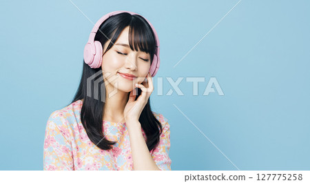 AI-generated image of a Japanese woman listening to music with headphones 127775258