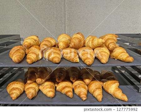Take a photo of neatly arranged freshly baked croissants in a restaurant 127775992