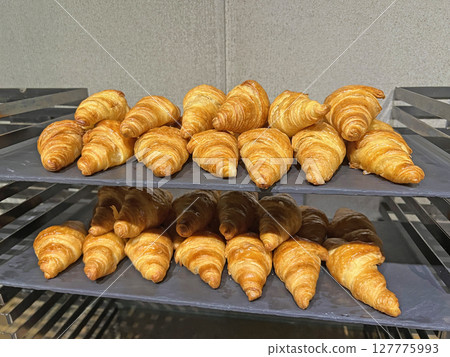 Take a photo of neatly arranged freshly baked croissants in a restaurant Take a photo of neatly arranged freshly baked croissants in a restaurant 127775993