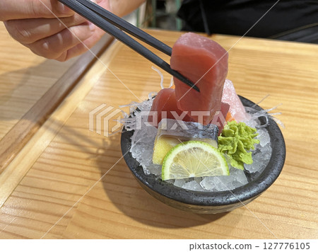 在日式居酒屋裡拍攝一份綜合生魚片 在日式居酒屋裡拍攝一份綜合生魚片 127776105