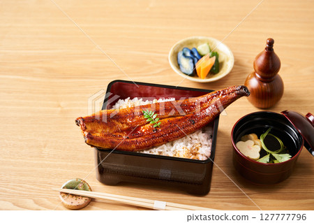 A whole grilled eel on rice A whole grilled eel on rice 127777796