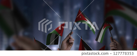 Jordan flags in their hands on a blurred urban background Jordan flags in their hands on a blurred urban background 127778353