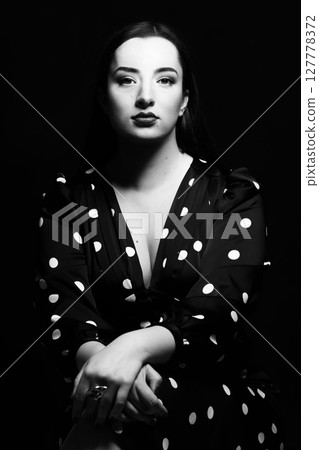 Beautiful woman with long dark hair black and white studio portrait 127778372