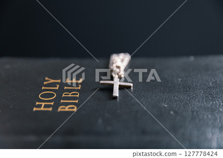 Religious belief concept Close up prayer Christian church service Bible Holy cross Spiritual power Blurred background Desk copy space Heaven God Catholic faith Praise book Jesus worship Gospel symbols 127778424