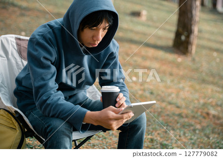 Remote work technology online close up communication smart phone laptop telephone digital travel brown nature sunlight camp beverage morning sit drink coffee tent orange outlying concept background. Remote work technology online close up communication smart phone laptop telephone digital travel brown nature sunlight camp beverage morning sit drink coffee tent orange outlying concept background. 127779082