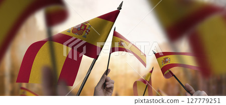 Spain flags in their hands on a blurred urban background 127779251