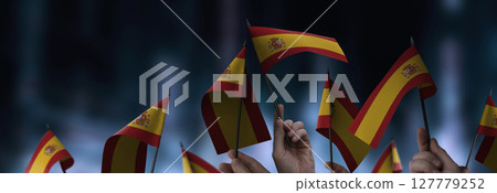 Spain flags in their hands on a blurred urban background 127779252