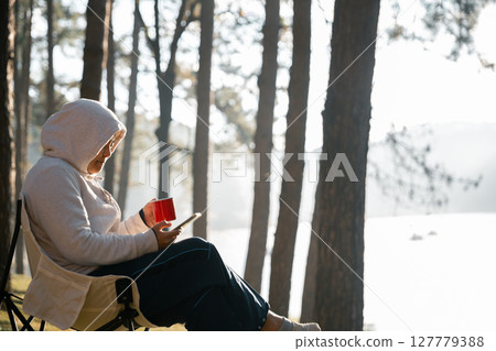 Remote work technology online close up communication smart phone laptop telephone digital travel brown nature sunlight camp beverage morning sit drink coffee tent orange outlying concept background. 127779388