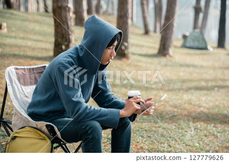 Remote work technology online close up communication smart phone laptop telephone digital travel brown nature sunlight camp beverage morning sit drink coffee tent orange outlying concept background. Remote work technology online close up communication smart phone laptop telephone digital travel brown nature sunlight camp beverage morning sit drink coffee tent orange outlying concept background. 127779626