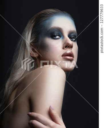 Beautiful woman with fancy make-up and naked shoulder studio portrait 127779633