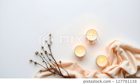 Elegant composition with three candles, a soft peach cloth, and delicate dry twigs, minimalist style. 127781138