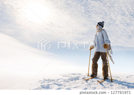 Portrait of a boy with old skis at the top of the hill. 127781971