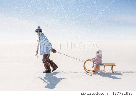 Children sled down the hill 127781983
