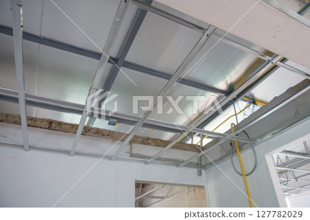 Hopeful interior renovation project showing aluminium ceiling framework and electrical wiring installation. Progress visible on structure and system for new room Hopeful interior renovation project showing aluminium ceiling framework and electrical wiring installation. Progress visible on structure and system for new room 127782029