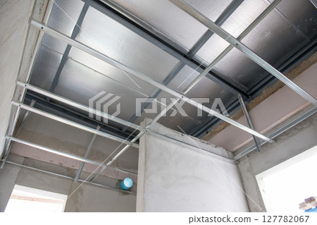 Aluminium ceiling framework during an interior renovation project. electrical wiring installation shows raw construction of building before final finishing stage Aluminium ceiling framework during an interior renovation project. electrical wiring installation shows raw construction of building before final finishing stage 127782067