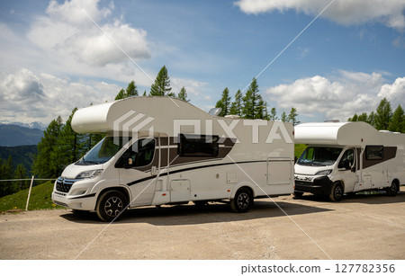Modern camper van parked in alpine nature under blue sky in Austrian Alps 127782356