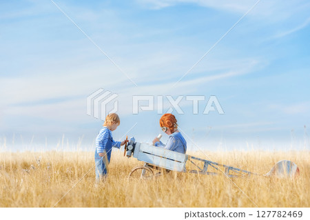 Little boys is playing the plane. 127782469