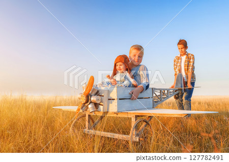 Little boys and girl is playing the plane. 127782491