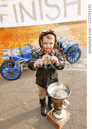 Young racer at the finish line with awards 127783101