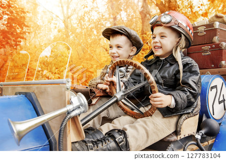 Young racer and mechanic riding an old race car Young racer and mechanic riding an old race car 127783104