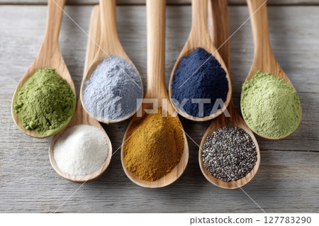 Colorful Variety of Spices and Powders on Wooden Spoons Display 127783290