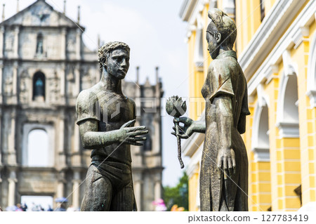 A sculpture of a young man and woman in front of the Ruins of St. Paul's at Jesus Company Square in Macau symbolizes the friendship between China and Portugal. 127783419