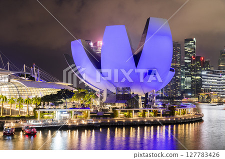 Night view of the Art Science Museum in Marina Bay, Singapore, with a skyscraper building background. The museum features major exhibitions that blend art, science, culture, and technology. Night view of the Art Science Museum in Marina Bay, Singapore, with a skyscraper building background. The museum features major exhibitions that blend art, science, culture, and technology. 127783426