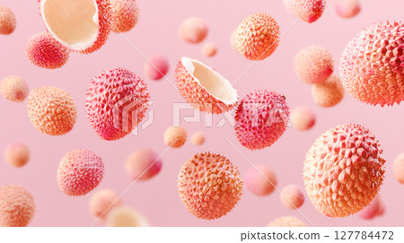 Floating lychee fruits with textured skin and cracked shells against a soft pink background, creating a vibrant and playful visual atmosphere 127784472