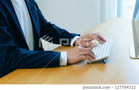 Hands of a man working on a computer Hands of a man working on a computer 127784722