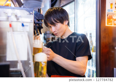 Izakaya beer server male staff pouring beer Izakaya beer server male staff pouring beer 127784782