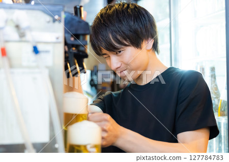 Izakaya beer server male staff pouring beer Izakaya beer server male staff pouring beer 127784783