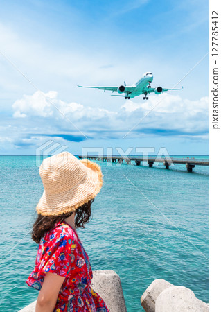 17 End: A young woman and a passenger plane passing overhead 17 End: A young woman and a passenger plane passing overhead 127785412