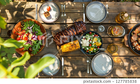 A picnic table with grilled meats, corn, and salads awaits friends for a delightful outdoor feast! A picnic table with grilled meats, corn, and salads awaits friends for a delightful outdoor feast! 127785838