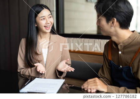 Entrepreneurial Discussion. Young professional explaining ideas in a cafe setting. 127786182