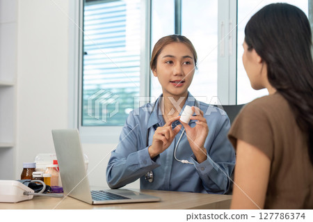 Patient Consultation. Doctor explaining medication details to patient using laptop. Patient Consultation. Doctor explaining medication details to patient using laptop. 127786374