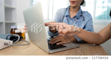 Doctor-Patient Interaction. Healthcare professional guiding patient through online health consultation. 127786426