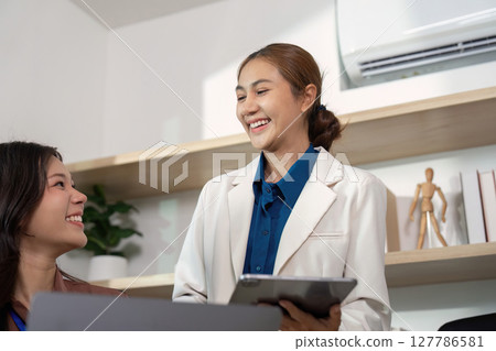 Positive Interaction. Professionals sharing insights and smiling during a meeting. Positive Interaction. Professionals sharing insights and smiling during a meeting. 127786581