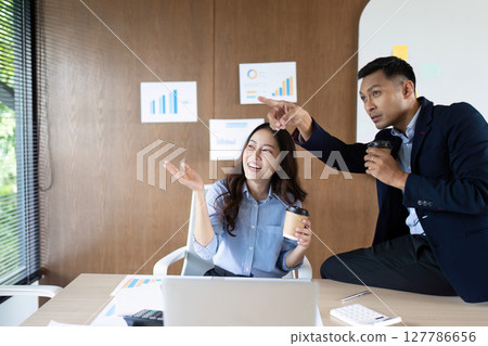 Collaboration and Success. Business team celebrating achievements in modern office. 127786656