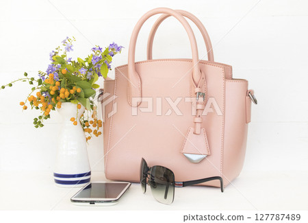 pink hand bag, mobile phone and sunglasses accessories of lifestyle woman pink hand bag, mobile phone and sunglasses accessories of lifestyle woman 127787489