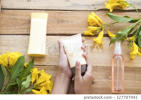 hand of girl holding sunscreen spf50, water spray for health care skin face with body lotion hand of girl holding sunscreen spf50, water spray for health care skin face with body lotion 127787491