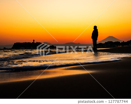 A man looking at the sunset at Shichirigahama Beach in Kamakura, Kanagawa Prefecture 127787744