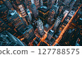Aerial shot of a bustling cityscape at dusk: skyscrapers, glowing streets, vibrant urban energy. 127788575
