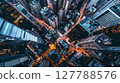 An aerial shot captures a bustling city at dusk, skyscrapers casting shadows, streets glowing with traffic. 127788576