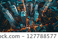 Aerial dusk view of skyscrapers casting shadows, with vibrant city lights creating a mesmerizing tapestry. 127788577