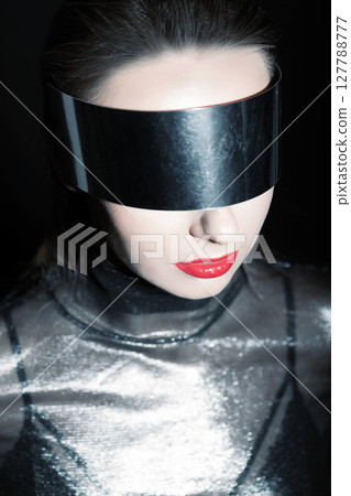 Abstract woman studio portrait with make-up and metallic eyeglasses or helmet covering her eyes Abstract woman studio portrait with make-up and metallic eyeglasses or helmet covering her eyes 127788777