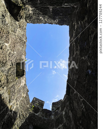Empty stone window border with blue sky and white clouds Empty stone window border with blue sky and white clouds 127789244