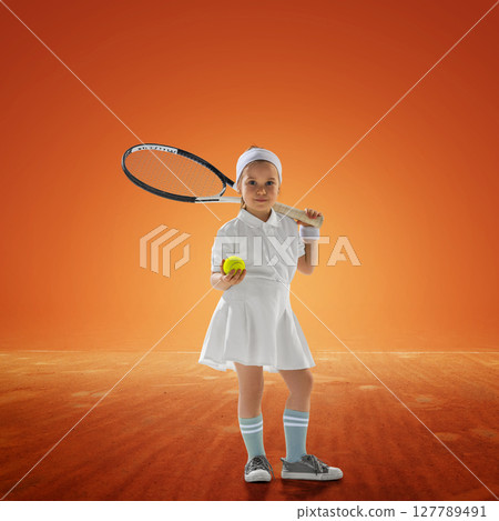 Young girl tennis player with racket and ball on clay court background. Youth athleticism Young girl tennis player with racket and ball on clay court background. Youth athleticism 127789491