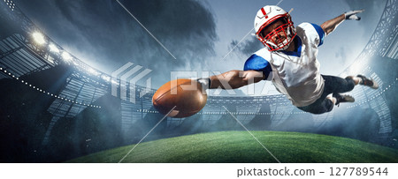 American football player mid-air dive reaching for the ball in dramatic 3D stadium 127789544
