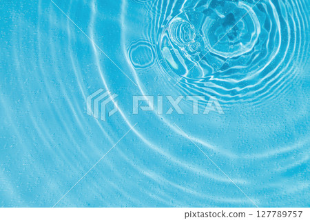 drops on water with circles on a blue background 127789757